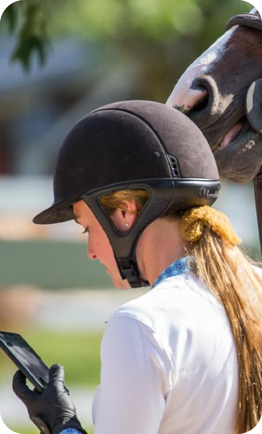 Equestrian rider reviewing scores on mobile device
